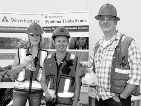 Weyerhaeuser representatives (l. to r.) summer student Kc Rhoades, summer student Chris Sopuch and Operation Planner Bill Taylor were busy handing out tree seedlings at the ECDC open house held June 22. They are now in the process of counting pine beetles in the area.