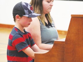 Evergreen School student Rogan plays a duet with music teacher Miss Cavanaugh during the talent show on June 24. Performances ranged from singing and dancing to a puppet show.