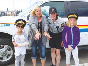 (l. to r.) Evergreen School student Nixon Demarais, Evergreen School Head Custodian Mrs. MacLeod,  RCMP Constable Stephanie Leduc and Evergreen School student Erica Pruden pose together after Mrs. MacLeod was handcuffed for refusing to do her work at the school until she got breakfast. The group took a trip to McDonald’s for breakfast on June 24, where Mrs. MacLeod promised to do her work after being taken back to the school.