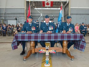 Corporal Rob Stanley/ 8 Wing Imaging
(From left to right) Lieutenant-colonel (Lt.-Col.) Brent Hoddinott, incoming Commanding officer of 426 (Transport Training) Squadron, Colonel Colin Keiver, Commander 8 Wing, and Lt.-Col. Ryan Deming sign the ceremonial certificates marking the official change of command on July 4.