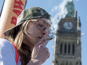 A woman smokes a joint during the annual 420 marijuana rally on Parliament hill on Wednesday, April 20, 2016 in Ottawa. (THE CANADIAN PRESS/Justin Tang)