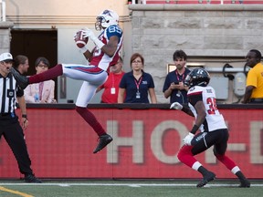 Alouettes wide receiver Duron Carter (left) catches a pass ahead of Redblacks defensive back Jonathan Rose during CFL action in Montreal on Thursday, June 30, 2016. Carter was suspended one game for bumping into and knocking over Redblacks head coach Rick Campbell during the game. (Paul Chiasson/The Canadian Press)