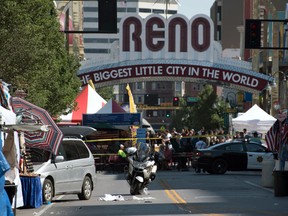 In this Sunday, July 3, 2016 photo, Reno police officers cordon off the area after a minivan, left, crashed into a vendor's tent at the Biggest Little City Wing Fest in downtown Reno, Nev. (Michael Higdon/The Reno Gazette-Journal via AP)