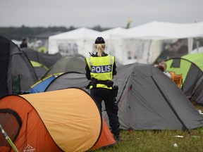 In this photo dated Saturday July 2, 2016,  a police officer helps with security in the campsite at Bravalla Festival in Norrkoping, Sweden, on Saturday July 2, 2016.   (Izabelle Nordfjell / TT via AP)