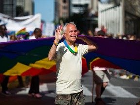 A man waves while carrying a rainbow flag at Toronto's Pride parade held in downtown Toronto on Sunday July 3, 2016. (Ernest Doroszuk/Toronto Sun/Postmedia Network)