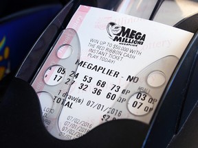 A Mega Millions lottery ticket is printed out of a lottery machine at a convenience store in Chicago, Friday, July 1, 2016. (AP Photo/Nam Y. Huh)