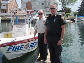 Chief Doug MacKenzie, left, of Point Edward Fire and Rescue, stands with Deputy Chief Rick MacGregor, next to one of the department's rescue boats on Tuesday July 5, 2016 in Point Edward, Ont. Village firefighters were called to a marine rescue Monday evening while they were involved in a training exercise on the St. Clair River. (Paul Morden, Sarnia Observer)
