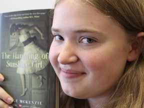 Samantha Reed/The Intelligencer
Taylor Bell holds one of the many books for sale at her downtown used bookstore. The 15-year-old started her bookstore with the help of the Summer Company Program, a province-funded program that helps young entrepreneurs start a summer business.