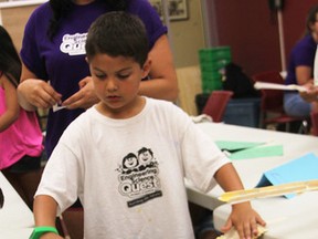 Jackson Antila, 8, tests a bridge he and fellow campers at an Aamjiwnaang science and technology camp built Tuesday. The Actua camp is designed to teach youngsters about science, technology, engineering and math. (Tyler Kula/Sarnia Observer/Postmedia Network)