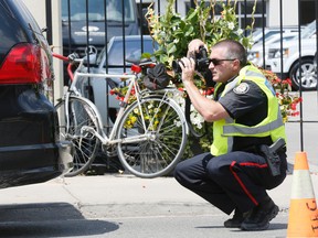 Toronto Police officers are pictured as they investigate the death of a cyclist. (STAN BEHAL, Toronto Sun)