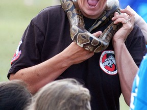 Jennifer Hache has a ball python snake around her neck during the Wallaceburg Canada Day celebrations at Kinsmen Park on Friday.