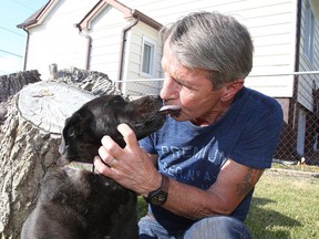 Rick Nelson of Sudbury gets a kiss from his dog Margie. The two encountered a mother bear and one of her cubs at Lake Panache on Sunday, with Nelson drawing on some old boxing skills to fight off the protective ursine parent. (Gino Donato/Sudbury Star)