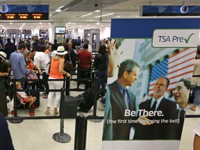 In this Thursday, May 26, 2016, photo, travelers stand in line as they prepare to pass through a Transportation Security Administration checkpoint at Miami International Airport, in Miami. The Transportation Security Administration said Tuesday, July 5, 2016, it will work with American Airlines to speed up security lines. The agency will test CT scanners in Phoenix, and roll out redesigned security lanes this fall in Chicago, Dallas, Los Angeles and Miami. (AP Photo/Alan Diaz)