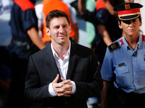 In this Sept. 27, 2013 file photo, FC Barcelona soccer player Lionel Messi, left, arrives at a court to answer questions in a tax fraud case in Gava, near Barcelona, Spain. A Barcelona court on July 6, 2016, sentenced Lionel Messi and his father Jorge Horacio Messi to 21 months in prison for tax fraud, with both sentences likely to be suspended. (AP Photo/Emilio Morenatti, File)