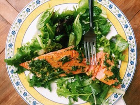 This May 13, 2016 photos a fillet of salmon smothered in an herb marinade served over a tender green salad, in New Milford, Conn. This warm-weather recipe combines salmon bathed in olive oil and herbs with spring-y greens and salad. It’s the kind of lighter, brighter meal we tend to want during summer.