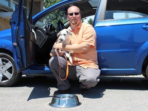 Samantha Reed/The Intelligencer
Frank Rockett, Quinte Humane Society executive director, holds a newly adopted puppy outside of the Quinte Humane Society Wednesday afternoon. Rockett is advising owners to keep animals out of hot cars.