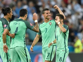 Portugal's Cristiano Ronaldo and his teammates celebrate at the end of the Euro 2016 semifinal match against Wales at the Grand Stade in Decines-Charpieu, near Lyon, France, on Wednesday, July 6, 2016. (Martin Meissner/AP Photo)