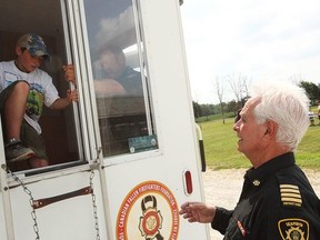 Seaforth's District Fire Chief, Tom Phillips helps a participant escape for the Progressive Agriculture Safety Day in Seaforth at the Agriplex. The Huron East Fire Department did a mock exercise, so the children knew what to do in a fire situation. (Shaun Gregory/Huron Expositor)