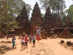 In this April 15, 2016 file photo, tourists walk at Banteay Srey temple of Angkor complex, in Siem Reap province, about 320 kilometers (199 miles) north of Phnom Penh, Cambodia. (AP Photo/Heng Sinith, File)