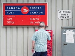 A man mails a letter outside a Canada Post office in Halifax on Wednesday, July 6, 2016. (THE CANADIAN PRESS/Darren Calabrese)