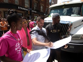 Pride Toronto executive director Mathieu Chantelois signs a list of demands from the Black Lives Matter movement as they stage a sit-in at the annual Pride Parade on July 3, 2016. (Mark Blinch/The Canadian Press)
