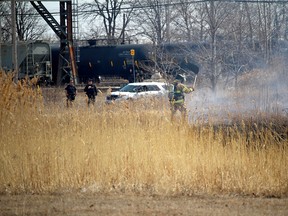 A Sarnia firefighter douses a grass fire near Campbell and Russell streets, in this file photo from 2015. Fire officials in Sarnia-Lambton have issued a ban on some opening burning, including burning brush piles, because of recent dry conditions. (File photo)