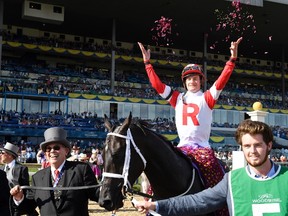 Jockey Julien Leparoux, riding Sir Dudley Digges, celebrates after winning the 157th running of the $1-million Queen’s Plate at Woodbine Racetrack. Owner Ken Ramsey (left) holds the reins. (Frank Gunn/CP)