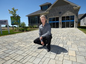 Richard Sifton shows the stones in the driveway of a net zero home in Sifton?s West 5 project in London, designed so water will be absorbed through the driveway and stored for reuse in the home.  (MORRIS LAMONT, The London Free Press)