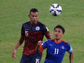 India's captain Sunil Chetri, right, and Guam's Shawn Nicklaw in action as it rains during their 2018 FIFA World Cup qualifying soccer match in Bangalore, India, Thursday, Nov. 12, 2015. India won the match 1-0. AP Photo / Aijaz Rahi