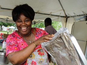 Rose Lindo shows off the jerk chicken she?s prepared for Sunfest that?s also available at her Wharncliffe Road eatery, Rose?s Tree of LIfe Caribbean Delight. She?s just one of the faces beyond the music at Sunfest. (JOE BELANGER, The London Free Press)
