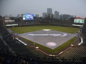 The field is covered by a tarp as rain falls before a game between the Chicago Cubs and the Atlanta Braves on July 7, 2016 at Wrigley Field in Chicago, Illinois.  (David Banks/Getty Images)