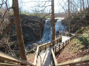 This April 24, 2016 file photo shows visitors on a walkway overlooking Brandywine Falls at Cuyahoga Valley National Park in Sagamore Hills, Ohio. The overlook is a short walk from the parking lot and offers a quick and scenic respite from nearby Cleveland. (AP Photo/Beth J. Harpaz, File)