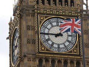 A Union flag is pictured flapping in front of one of the faces of the Great Clock atop the landmark Elizabeth Tower that houses Big Ben at the Houses of Parliament in London. (AFP PHOTO)