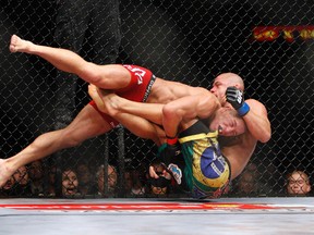 Georges St. Pierrre (left) takes down Thiago Alves during their welterweight title bout at UFC 100 in Las Vegas on July 11, 2009. (John Locher/Las Vegas Review-Journal via AP)