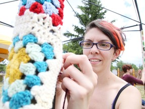 Marja Reimer "yarn bombs" the Sew Local tent in preparation for Northern Lights Festival Boreal in 2016. (Gino Donato/Sudbury Star)