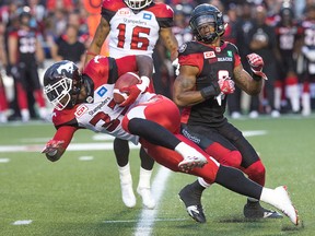 Calgary Stampeders running back Jerome Messam tries to squeeze past Jermaine Robinson of the Redblacks during the home opener at TD Place. (Wayne Cuddington, Postmedia Network)