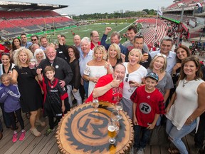OSEG president of sports Jeff Hunt (behind the boy with his arm up) invited 50-plus people to his condo for a CHEO fundraiser. (Wayne Cuddington, Postmedia Network)