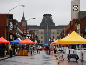Pedestrians walk past mostly empty patios during the rainy afternoon on the first day of Clarence Street Patio Fest, Saturday, July 9, 2016. James Park/Postmedia