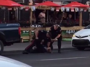 Screen grab of video posted to social media showing part of a confrontation between a man and three police officers on 17 Ave. S.W. in the downtown core.