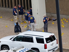 Members of an FBI evidence response team work at the scene of the attack on police officers in Dallas, Saturday, July 9, 2016. A peaceful protest over the recent videotaped shootings of black men by police turned violent Thursday night as gunman Micah Johnson fatally shot several officers. (AP Photo/Gerald Herbert)