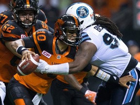 B.C. Lions’ quarterback Jonathon Jennings, left, is sacked by Toronto Argonauts’ Ken Bishop during CFL action in Vancouver, B.C., on Thursday July 7, 2016. (THE CANADIAN PRESS/Darryl Dyck)