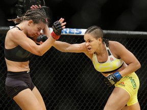 Amanda Nunes, right, hits Miesha Tate during their women's bantamweight championship mixed martial arts bout at UFC 200, Saturday, July 9, 2016, in Las Vegas. (AP Photo/John Locher)