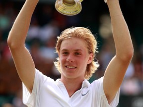 Denis Shapovalov of Canada lifts the trophy as celebrates victory during the Boy's Singles Final against Alex De Minaur of Australia on day thirteen of the Wimbledon Lawn Tennis Championships at the All England Lawn Tennis and Croquet Club on July 10, 2016 in London, England.  (Photo by Adam Pretty/Getty Images)