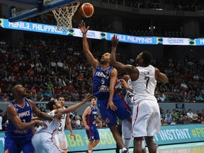 Tony Parker (C) of France lays-up against Melvin Ejim of Canada during their game at the 2016 FIBA Olympic men's qualifying basketball tournament in Manila on July 10, 2016. / AFP PHOTO / TED ALJIBETED ALJIBE/AFP/Getty Images