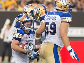 Winnipeg Blue Bombers wide receiver Ryan Smith (12) is congratulated by teammates after his touchdown during first half CFL football action against the Hamilton Tiger Cats, in Hamilton, Ont., on Thursday, July 7, 2016. THE CANADIAN PRESS/Peter Power