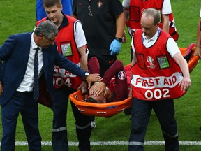 Cristiano Ronaldo of Portugal shows his emotion while being taken off by a stretcher during the UEFA EURO 2016 Final match between Portugal and France at Stade de France on July 10, 2016 in Paris, France. (Photo by Alex Livesey/Getty Images)