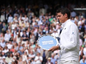Canada's Milos Raonic poses with the runners up plate after losing the men's singles final to Britain's Andy Murray on the last day of the 2016 Wimbledon Championships at The All England Lawn Tennis Club in Wimbledon, southwest London, on July 10, 2016. (ANDREW COULDRIDGE/AFP/Getty Images)