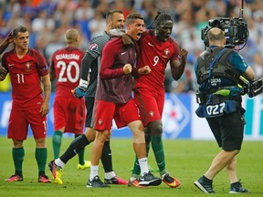 Portugal's Cristiano Ronaldo and Eder celebrate at the end of the Euro 2016 final soccer match between Portugal and France at the Stade de France in Saint-Denis, north of Paris, Sunday, July 10, 2016. Portugal won the match 1-0. (AP Photo/Michael Probst)