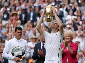 Andy Murray of Britain holds up his trophy after beating Milos Raonic of Canada in the men's singles final on day fourteen of the Wimbledon Tennis Championships in London, Sunday, July 10, 2016. (Andy Couldridge/Pool Photo via AP)