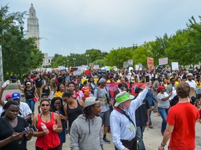 Protesters march to the state Capitol in Baton Rouge, La., Sunday, July 10, 2016. People are protesting the shooting death of a black man, Alton Sterling, by two white police officers at a convenience store parking lot last week. (Scott Clause/The Daily Advertiser via AP)